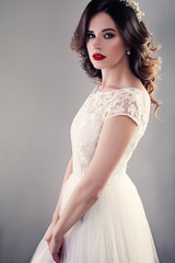 Nice Bride in White Wedding Dress, Pretty Girl Fiancee with Curly Hair and Makeup on Background