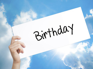 Birthday Sign on white paper. Man Hand Holding Paper with text. Isolated on sky background