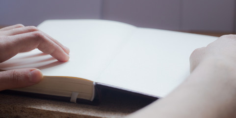 Female hands holding diary on the wooden desk. With space for text