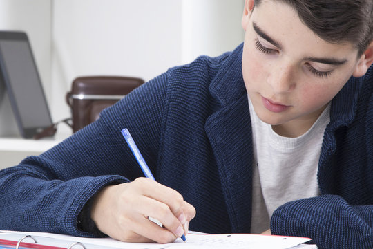 Child Writing In The Book At School