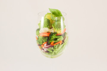 Mix cabbage romanesko, cauliflower and broccoli, sweet carrots and peppers on lettuce, capped with basil