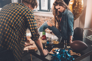 man and woman cleaning messy room after party