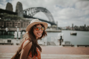 Happy woman exploring Sydney, with Harbour Bridge in the background. Australia. - obrazy, fototapety, plakaty
