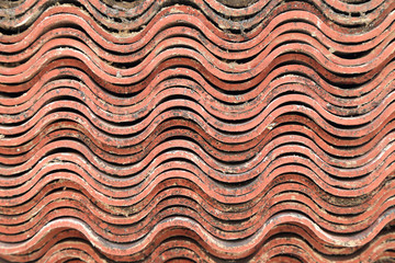 Stack of baked clay roof tiles, abstract background.