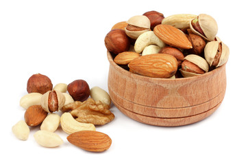 mix almonds, cashew nuts, hazelnut, peanuts, walnuts, pistachio in wood plate isolated on white...