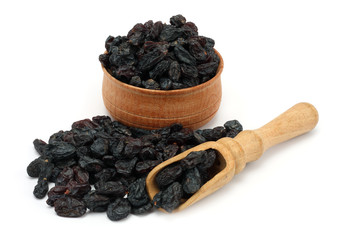 Organic dried Raisins in wood plate isolated on white background