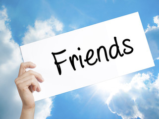 Friends Sign on white paper. Man Hand Holding Paper with text. Isolated on sky background