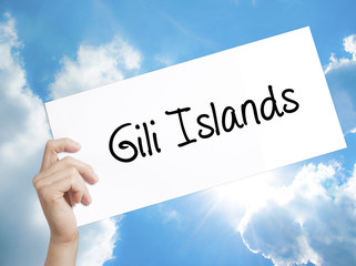 Gili Islands Sign on white paper. Man Hand Holding Paper with text. Isolated on sky background