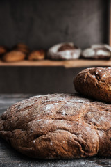 Bread with flour on dark wooden table at bakery