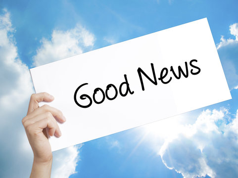 Good News Sign on white paper. Man Hand Holding Paper with text. Isolated on sky background