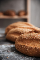 Bread with flour on dark wooden table