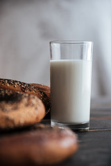 Pastries and glass of milk on dark wooden table