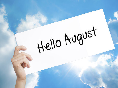 Hello August Sign on white paper. Man Hand Holding Paper with text. Isolated on sky background