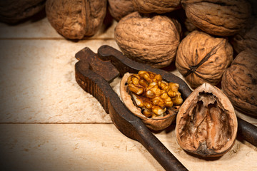 Close up of walnuts with an old nutcracker on a wooden table