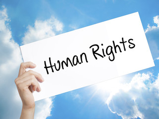 Human Rights Sign on white paper. Man Hand Holding Paper with text. Isolated on sky background