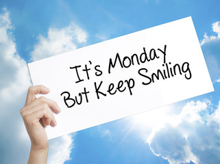 It's Monday But Keep Smiling Sign on white paper. Man Hand Holding Paper with text. Isolated on sky...