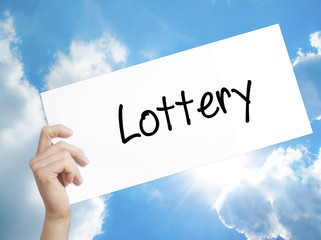 Lottery  Sign on white paper. Man Hand Holding Paper with text. Isolated on sky background