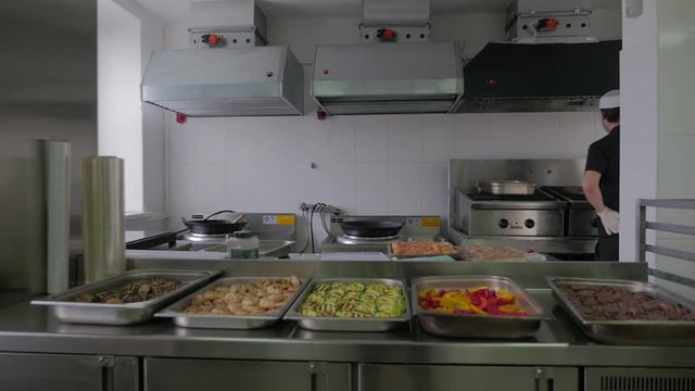 Chef cooking in kitchen in restaurant. Restaurant kitchen, chef cooking food, man as professional cook at work.