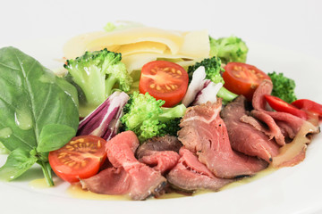 Beef tenderloin mix with parmesan cheese, with broccoli cabbage and cherry tomatoes, dressed with citrus sauce