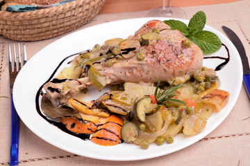 Dish with turkey thigh and side dish of potatoes and zucchini orange pepper
