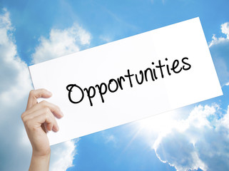 Opportunities  Sign on white paper. Man Hand Holding Paper with text. Isolated on sky background