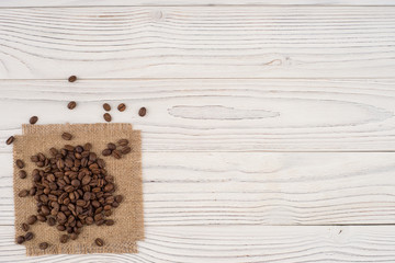 Coffee beans on sacking and an old white table.