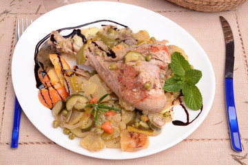 Dish with turkey thigh and side dish of potatoes and zucchini orange pepper
