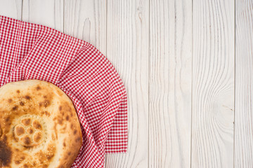 Uzbek bread on old white wooden table.
