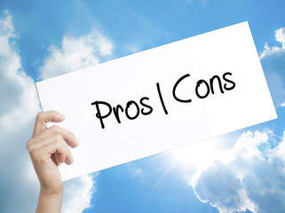 Pros  Cons Sign on white paper. Man Hand Holding Paper with text. Isolated on sky background