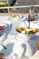 Greek salad or Fresh tasty vegetable salad with white feta cheese on the table in Restaurant on a beach.