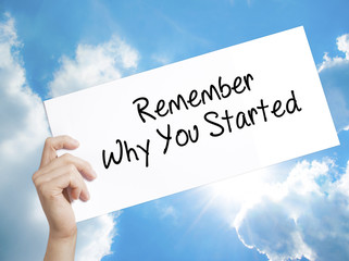 Remember Why You Started Sign on white paper. Man Hand Holding Paper with text. Isolated on sky...