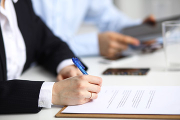 Businesswoman sitting in office, writing on documents