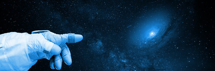 astronaut pointing to a galaxy, background banner © dottedyeti