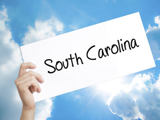 South Carolina Sign on white paper. Man Hand Holding Paper with text. Isolated on sky background.