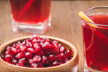 juice of pomegranate and stone on a wooden background/two red cocktails on a wooden background