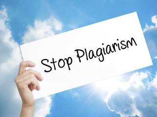 Stop Plagiarism Sign on white paper. Man Hand Holding Paper with text. Isolated on sky background