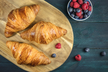 Crunchy French croissants with fresh raspberries and blueberries