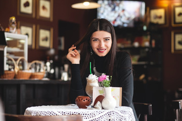 Portrait of a beautiful girl reading book in cafe