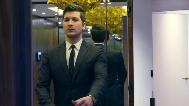 Fashionable businessman standing in front of the mirror