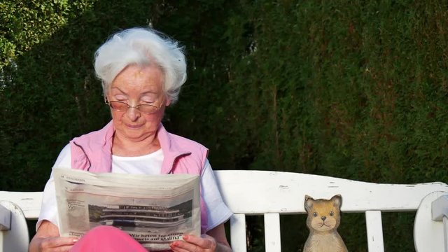 Seniorin beim Zeitung lesen