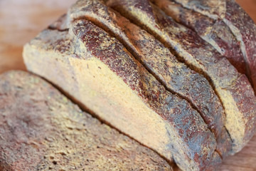 Slices of old moldy rye bread on wooden shelf