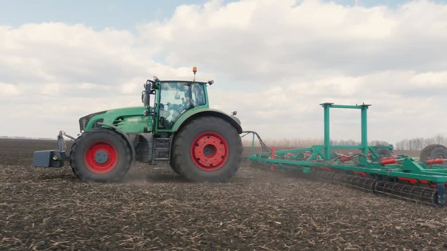Agrobusiness - tractor running in the field in the spring 3-axis stabilized video