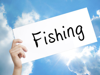 Fishing Sign on white paper. Man Hand Holding Paper with text. Isolated on sky background