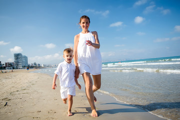 Mother and her son have fun at seashore of Mediterranean sea