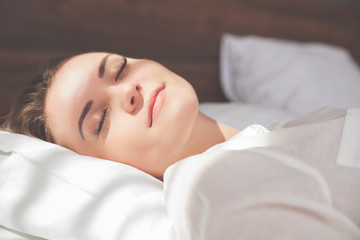 Fototapeta premium Pretty woman on bed in modern apartment smiling after wake up