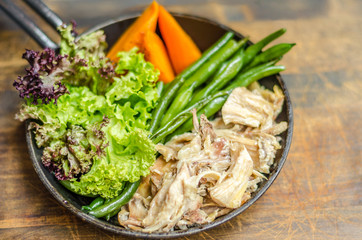 Frying pan with meat, carrots, asparagus and herbs, stands