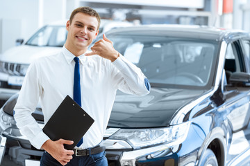 Young car dealer at the car salon