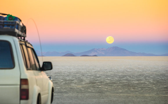 Full Moon Sunset With Off Road Jeep Vehicle On Salar De Uyuni - World Famous Nature Wonder Place In Bolivia - Travel And Wanderlust Concept In South American Exclusive Landscape - Focus On Infinity