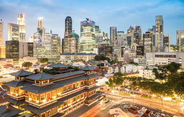 Fototapeta na wymiar High view of Singapore skyline with skyscrapers and Tooth Relic Temple at blue hour - World famous top south east Asia destinations - City panorama on vivid warm filter with nightscape color tones