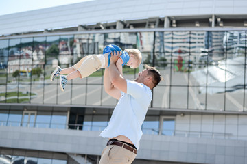 Dad playing with baby on street